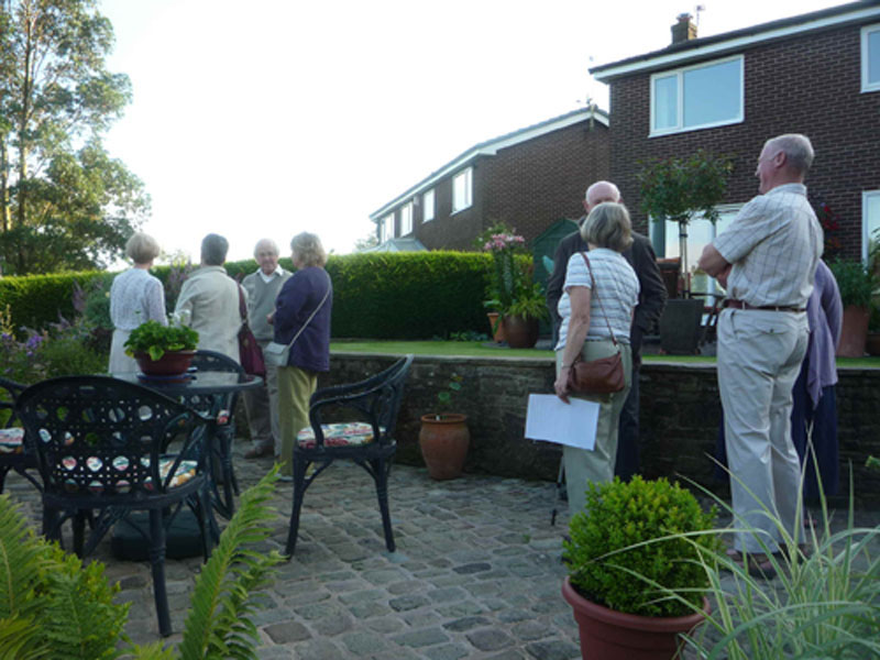 Members enjoying the beautiful summer
                    evening on the middle patio at David & Amanda's